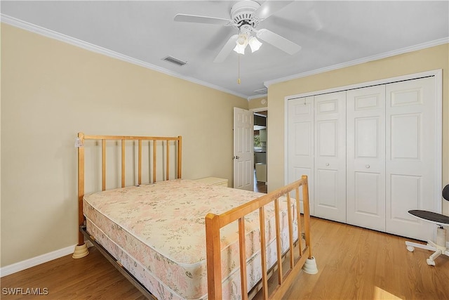 7836 Grande Pine Rd, Bokeelia, FL 33922 - bedroom featuring ornamental molding, light wood-style floors, a closet, a ceiling fan, and baseboards