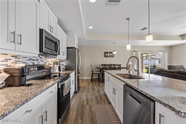 1929 NW 18th St, Cape Coral, FL 33993 - kitchen with appliances with stainless steel finishes, a sink, dark wood-style flooring, white cabinets, and recessed lighting
