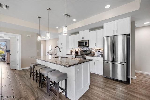 1929 NW 18th St, Cape Coral, FL 33993 - kitchen featuring stainless steel appliances, a sink, baseboards, a center island with sink, and a kitchen breakfast bar