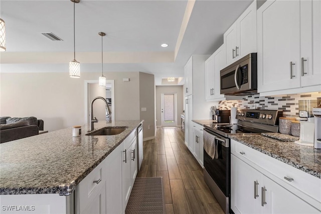 1929 NW 18th St, Cape Coral, FL 33993 - kitchen featuring appliances with stainless steel finishes, a sink, decorative backsplash, dark wood-type flooring, and white cabinetry