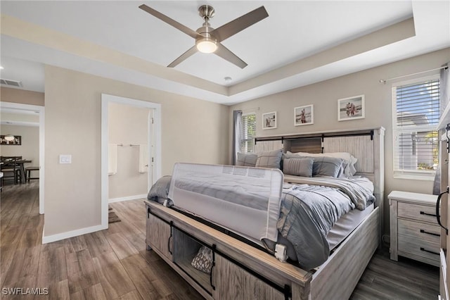 1929 NW 18th St, Cape Coral, FL 33993 - bedroom with dark wood-type flooring, a tray ceiling, and baseboards