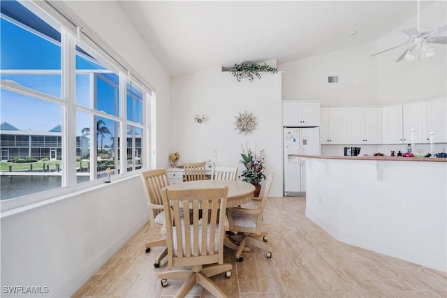 2871 Bracci Dr, Saint James City, FL 33956 - dining space with high vaulted ceiling, a ceiling fan, healthy amount of natural light, light tile patterned flooring, and baseboards