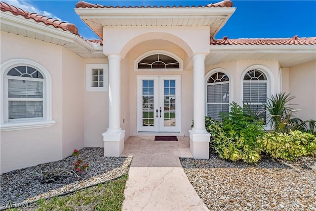 2871 Bracci Dr, Saint James City, FL 33956 - view of exterior entry featuring stucco siding, french doors, and a tiled roof