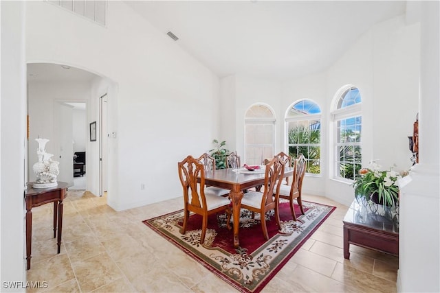 2871 Bracci Dr, Saint James City, FL 33956 - dining area featuring arched walkways, a high ceiling, and light tile patterned floors