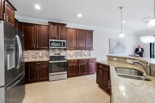 26304 Prince Pierre Way, Bonita Springs, FL 34135 - kitchen with stainless steel appliances, ornamental molding, tasteful backsplash, decorative light fixtures, and light stone countertops