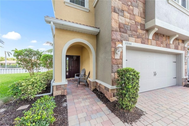 10844 Alvara Point Dr, Bonita Springs, FL 34135 - doorway to property featuring stone siding, stucco siding, and an attached garage