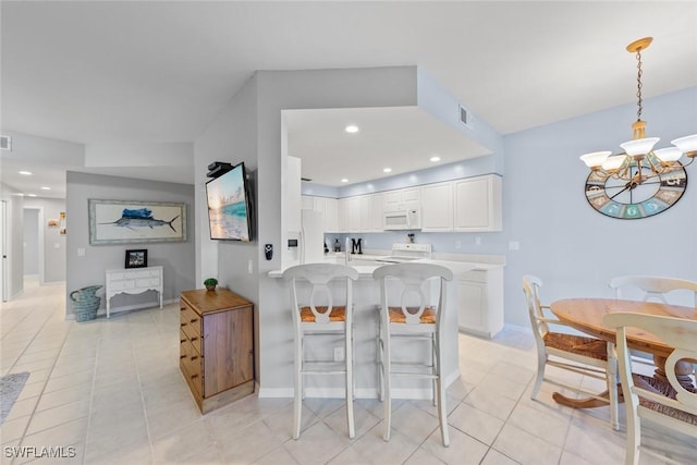 4410 Riverwatch Dr Unit 102, Bonita Springs, FL 34134 - kitchen with white appliances, light tile patterned floors, white cabinets, a chandelier, and light countertops