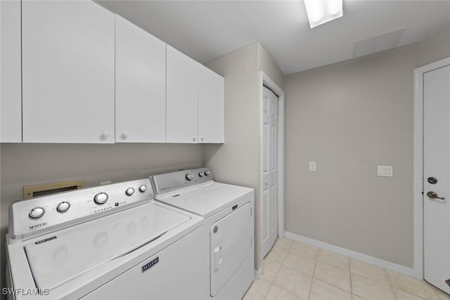 4410 Riverwatch Dr Unit 102, Bonita Springs, FL 34134 - laundry room with cabinet space, washing machine and clothes dryer, baseboards, and light tile patterned floors