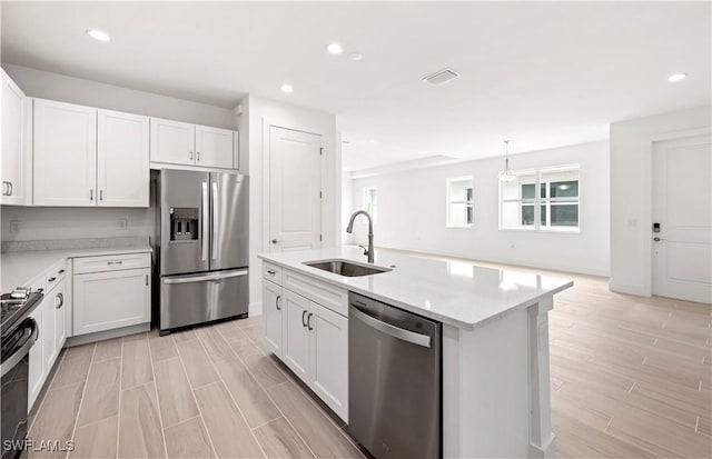 44320 Panther Dr, Punta Gorda, FL 33982 - kitchen featuring appliances with stainless steel finishes, white cabinetry, recessed lighting, light wood-style floors, and an island with sink