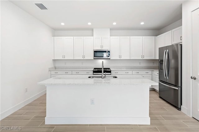 44320 Panther Dr, Punta Gorda, FL 33982 - kitchen with appliances with stainless steel finishes, wood finish floors, light stone countertops, and recessed lighting