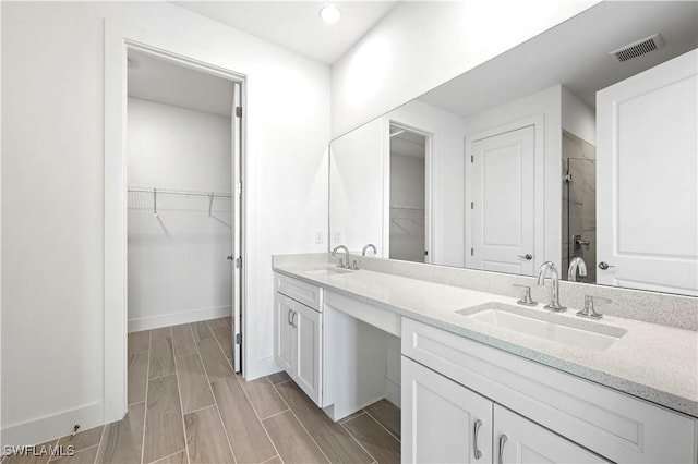 44320 Panther Dr, Punta Gorda, FL 33982 - full bath featuring a stall shower, double vanity, a walk in closet, wood finish floors, and recessed lighting