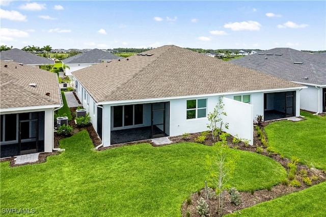 44320 Panther Dr, Punta Gorda, FL 33982 - back of house with a sunroom, a shingled roof, stucco siding, and a lawn
