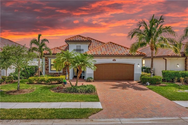 12732 Kinross Ln, Naples, FL 34120 - mediterranean / spanish home featuring a garage, decorative driveway, stucco siding, a tile roof, and a front lawn