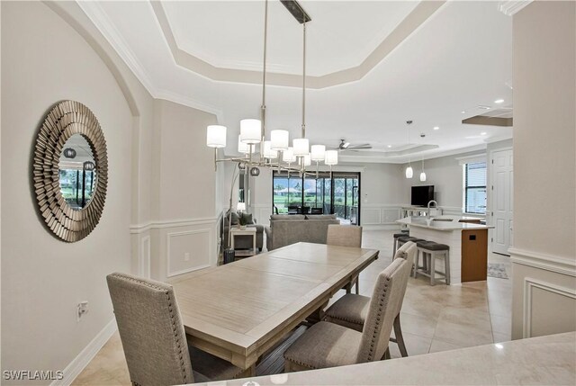 12732 Kinross Ln, Naples, FL 34120 - dining area with a tray ceiling, a decorative wall, healthy amount of natural light, a chandelier, and light tile patterned flooring