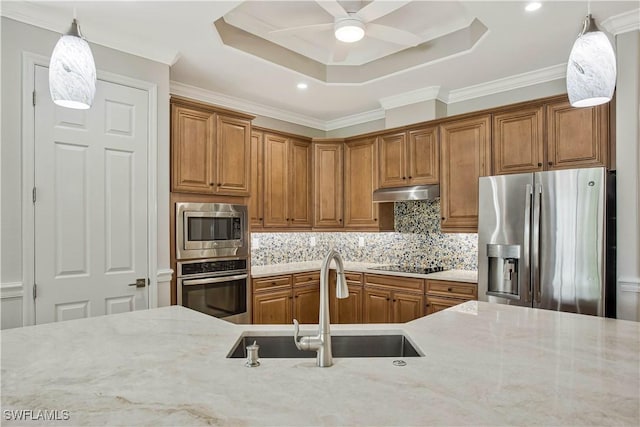 12732 Kinross Ln, Naples, FL 34120 - kitchen with appliances with stainless steel finishes, a sink, a raised ceiling, brown cabinetry, and ornamental molding