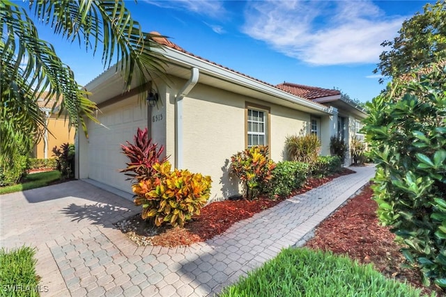 8515 Chase Preserve Dr, Naples, FL 34113 - view of home's exterior with stucco siding, driveway, and a garage