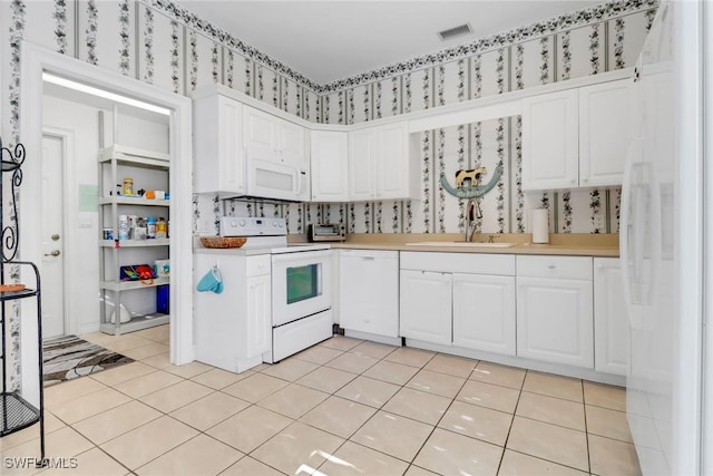8515 Chase Preserve Dr, Naples, FL 34113 - kitchen featuring white appliances, a sink, white cabinetry, and light countertops
