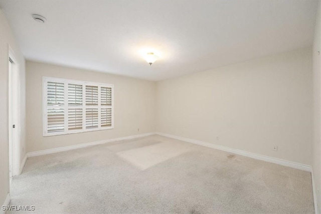 5964 Pelican Bay Blvd Unit 415, Naples, FL 34108 - unfurnished room featuring light carpet, baseboards, and a smoke detector