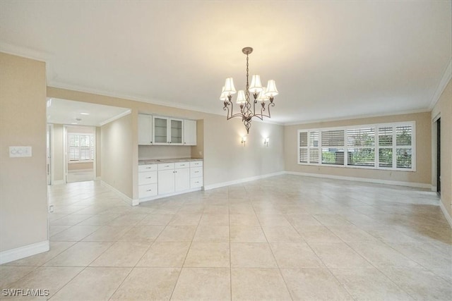 5964 Pelican Bay Blvd Unit 415, Naples, FL 34108 - empty room featuring ornamental molding, light tile patterned flooring, a chandelier, and baseboards