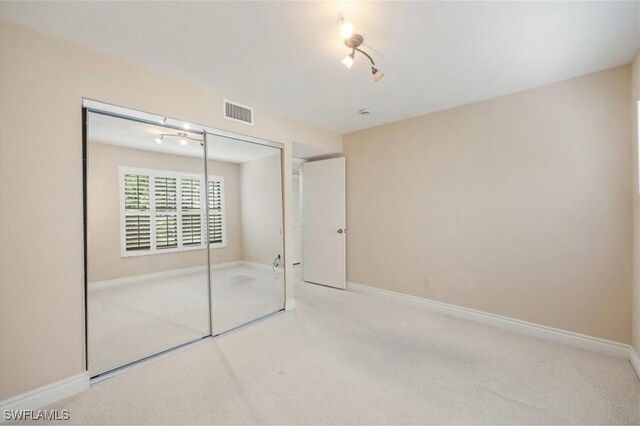 5964 Pelican Bay Blvd Unit 415, Naples, FL 34108 - unfurnished bedroom featuring carpet, a closet, baseboards, and track lighting