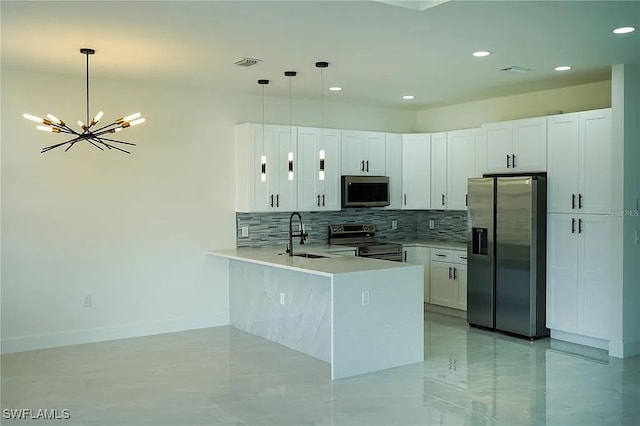 3017 4th St W, Lehigh Acres, FL 33971 - kitchen featuring appliances with stainless steel finishes, a sink, a peninsula, backsplash, and a chandelier