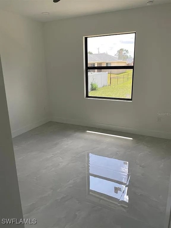 3017 4th St W, Lehigh Acres, FL 33971 - unfurnished room featuring baseboards and concrete floors