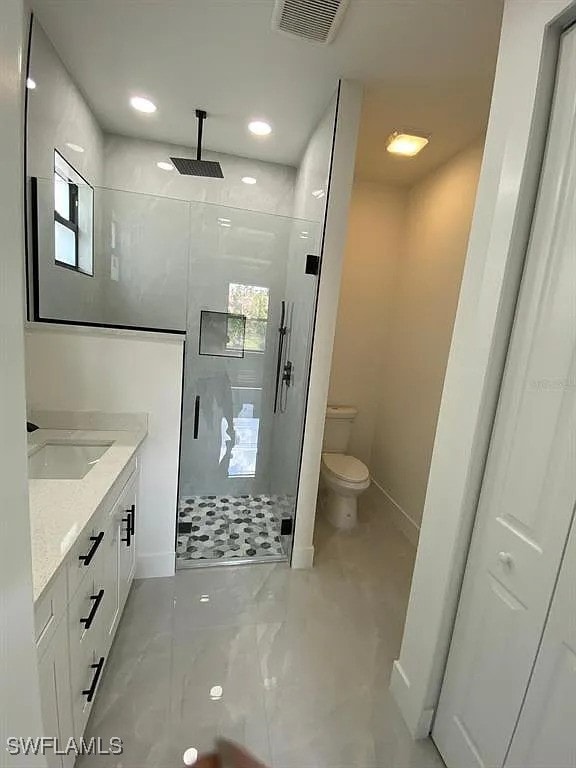 3017 4th St W, Lehigh Acres, FL 33971 - full bathroom featuring a shower stall, toilet, vanity, baseboards, and recessed lighting