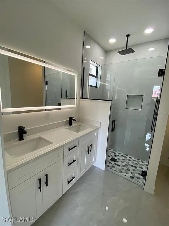 3017 4th St W, Lehigh Acres, FL 33971 - bathroom featuring a stall shower, double vanity, recessed lighting, and marble finish flooring