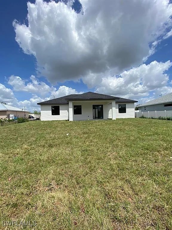 3017 4th St W, Lehigh Acres, FL 33971 - back of property featuring a yard and stucco siding
