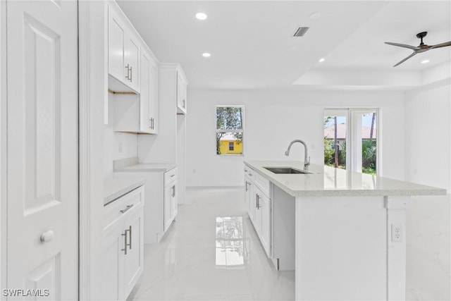 3507 41st St SW, Lehigh Acres, FL 33976 - kitchen with a sink, an island with sink, recessed lighting, light marble finish floors, and white cabinetry