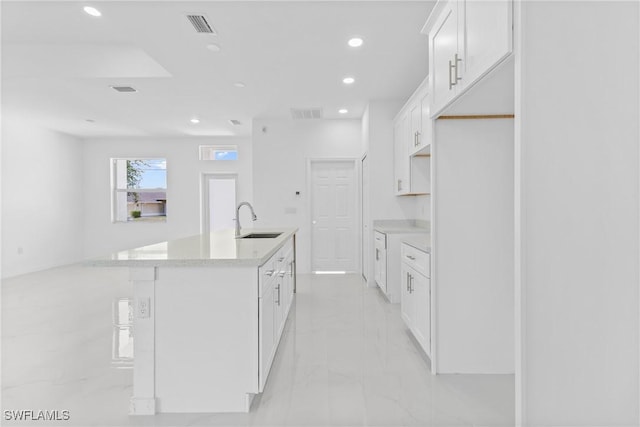 3507 41st St SW, Lehigh Acres, FL 33976 - kitchen with a sink, recessed lighting, light marble finish flooring, an island with sink, and white cabinetry