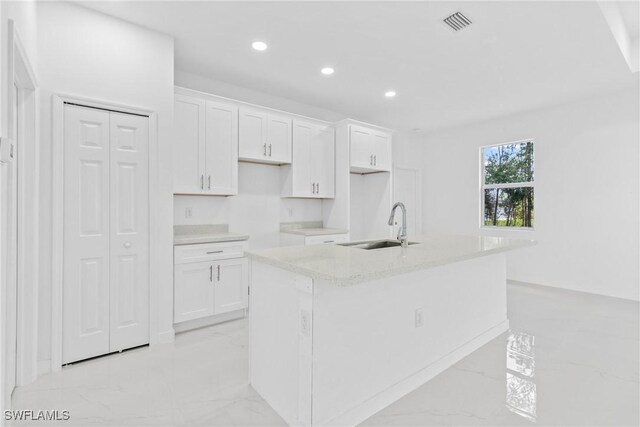 3507 41st St SW, Lehigh Acres, FL 33976 - kitchen with a sink, light marble finish flooring, white cabinetry, a kitchen island with sink, and recessed lighting