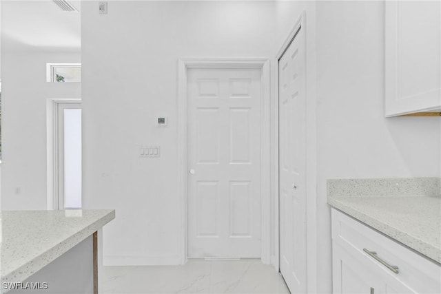 3507 41st St SW, Lehigh Acres, FL 33976 - kitchen featuring light marble finish flooring, white cabinetry, and light stone countertops