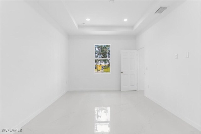 3507 41st St SW, Lehigh Acres, FL 33976 - empty room featuring recessed lighting, a tray ceiling, baseboards, and light marble finish flooring