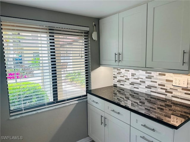 11460 Caravel Cir Unit 5009, Fort Myers, FL 33908 - kitchen featuring tasteful backsplash, baseboards, dark stone counters, and white cabinets