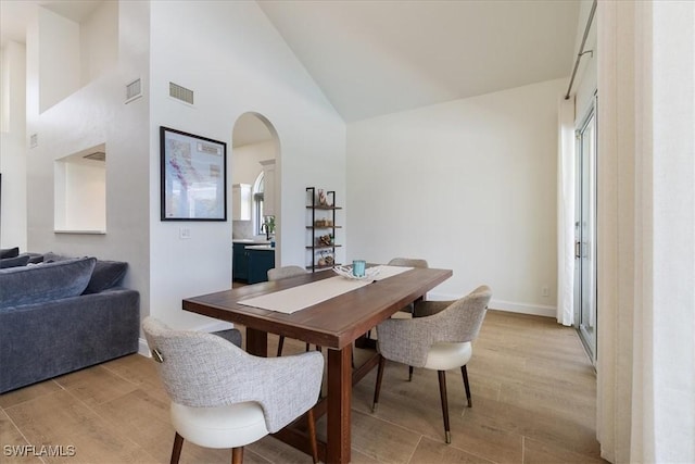 171 Via Napoli, Naples, FL 34105 - dining space with light wood-type flooring, arched walkways, and high vaulted ceiling