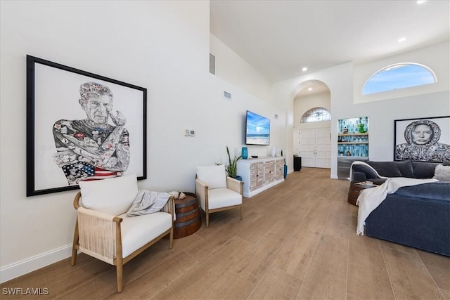 171 Via Napoli, Naples, FL 34105 - living area featuring light wood finished floors, a towering ceiling, recessed lighting, arched walkways, and baseboards