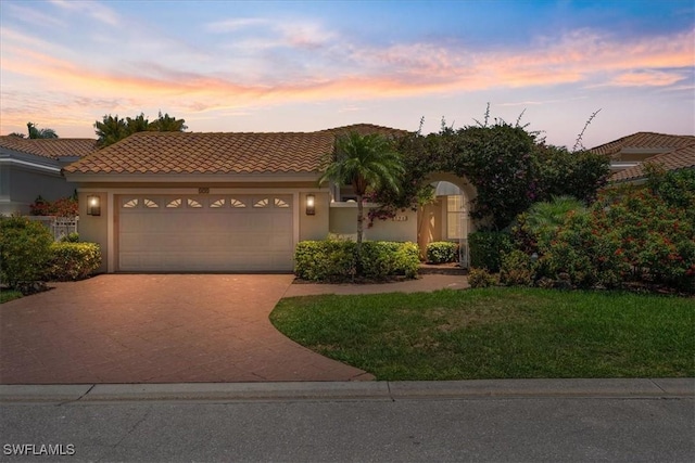171 Via Napoli, Naples, FL 34105 - mediterranean / spanish-style home featuring stucco siding, driveway, an attached garage, a tiled roof, and a lawn
