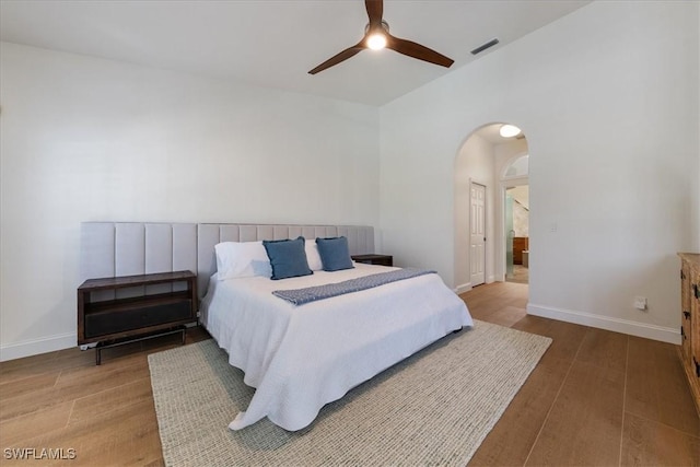 171 Via Napoli, Naples, FL 34105 - bedroom with wood finished floors, arched walkways, baseboards, lofted ceiling, and ceiling fan