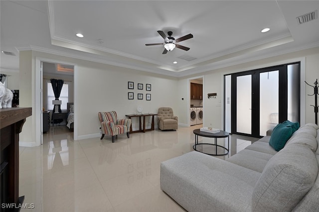 3460 4th Ave NE, Naples, FL 34120 - living area featuring a raised ceiling, washer and dryer, a ceiling fan, crown molding, and baseboards