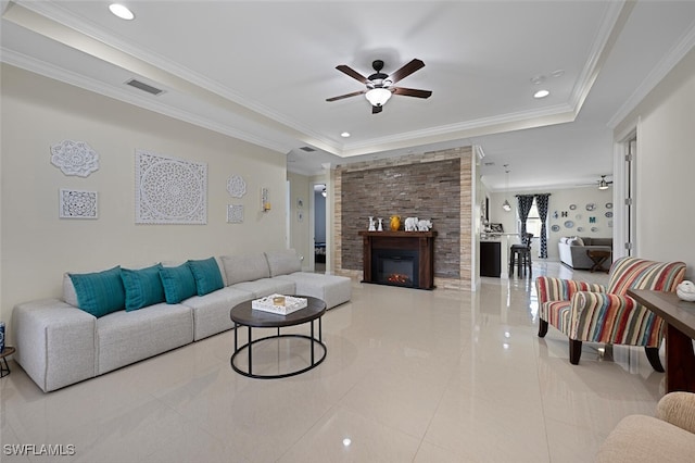 3460 4th Ave NE, Naples, FL 34120 - living area featuring tile patterned flooring, a raised ceiling, ceiling fan, a glass covered fireplace, and crown molding