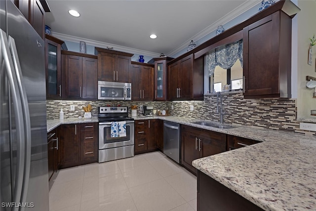 3460 4th Ave NE, Naples, FL 34120 - kitchen featuring stainless steel appliances, a sink, ornamental molding, light stone counters, and dark brown cabinetry