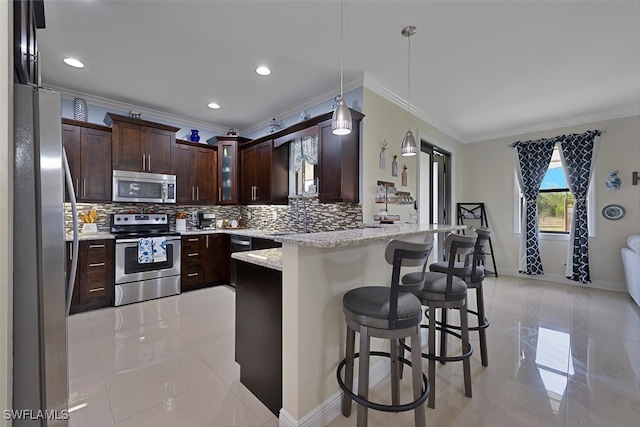 3460 4th Ave NE, Naples, FL 34120 - kitchen featuring appliances with stainless steel finishes, crown molding, a peninsula, backsplash, and a kitchen bar