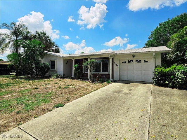 4268 25th Ave SW, Naples, FL 34116 - ranch-style house featuring a garage, driveway, stucco siding, and metal roof