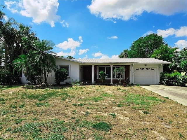 4268 25th Ave SW, Naples, FL 34116 - ranch-style house with an attached garage, concrete driveway, stucco siding, metal roof, and a front yard