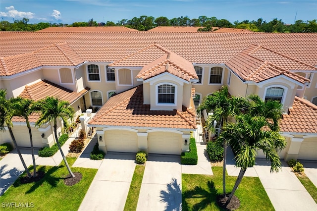 15055 Tamarind Cay Ct Unit 1205, Fort Myers, FL 33908 - mediterranean / spanish home featuring a tiled roof, stucco siding, concrete driveway, and a garage