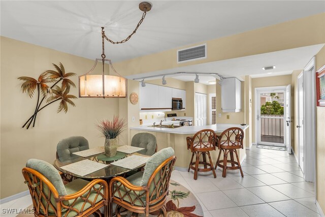 991 N Barfield Dr Unit 110, Marco Island, FL 34145 - dining room featuring light tile patterned flooring, baseboards, and rail lighting