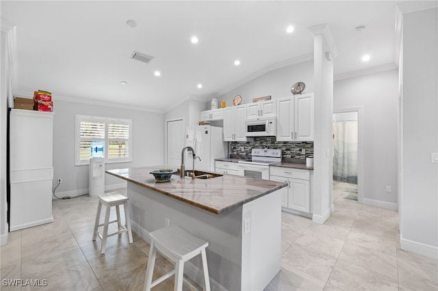 1187 16th Ave NE, Naples, FL 34120 - kitchen with white appliances, crown molding, an island with sink, a kitchen breakfast bar, and vaulted ceiling