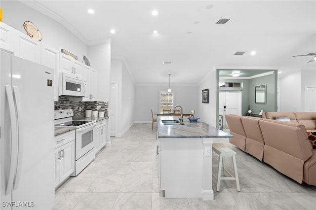 1187 16th Ave NE, Naples, FL 34120 - kitchen featuring white appliances, a sink, open floor plan, recessed lighting, and a kitchen bar