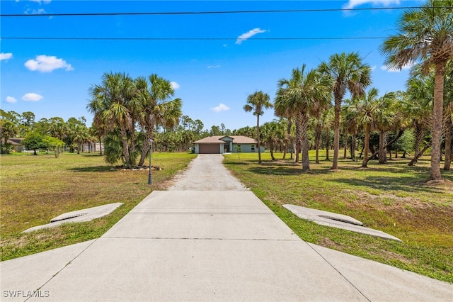 1187 16th Ave NE, Naples, FL 34120 - view of home's community with a lawn, a detached garage, and driveway